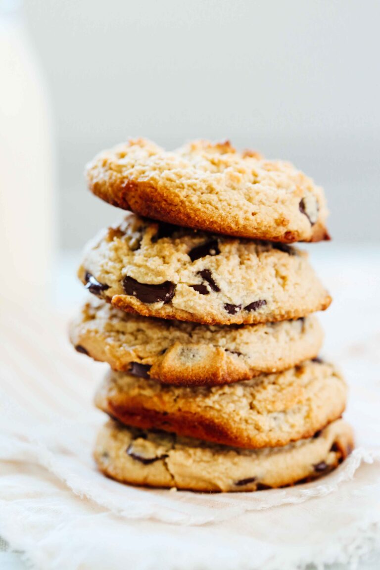 Chocolate chip cookies stacked on top of one another on a countertop.