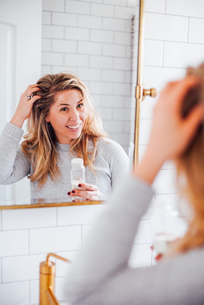 Massaging dry shampoo on your scalp. 