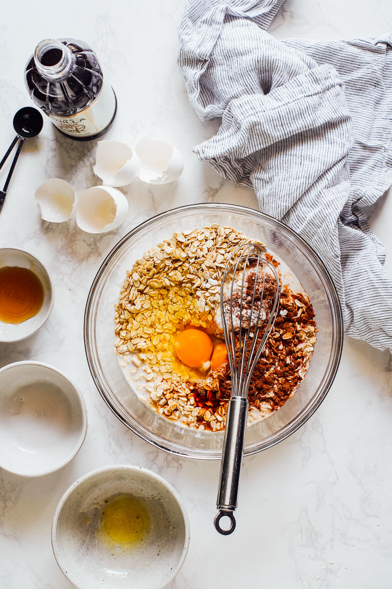 Adding wet ingredients to the dry ingredients in a large glass bowl.