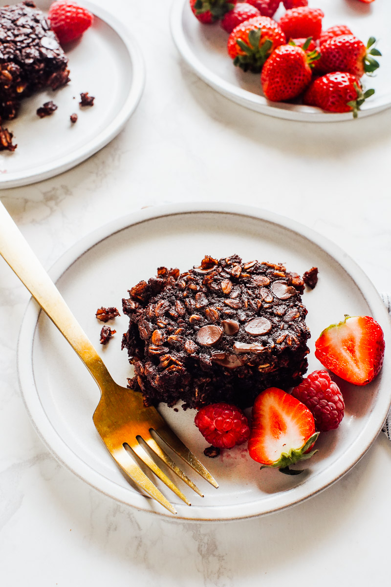 A square of baked oatmeal plated with berries.