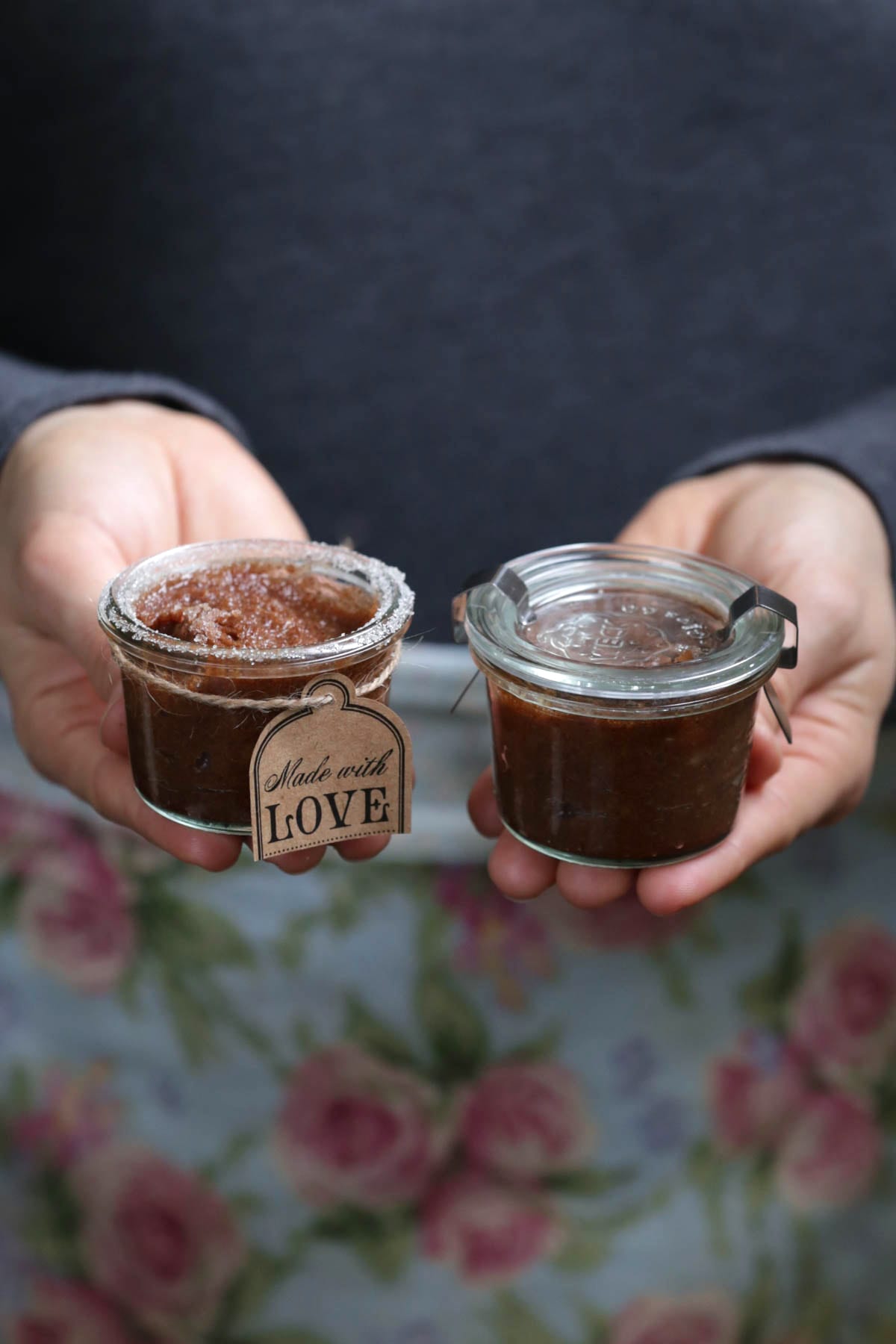 Holding jars of homemade lip scrub. 