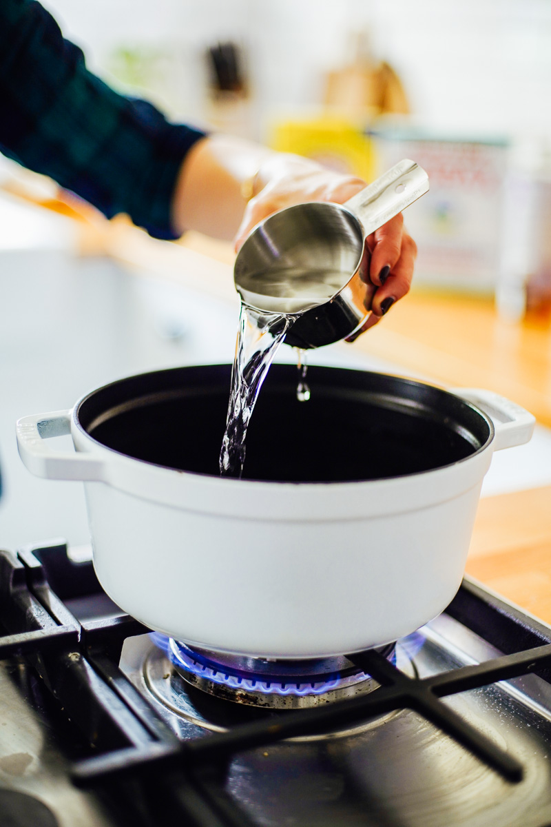 Pouring water into a large dutch oven to make the soap.