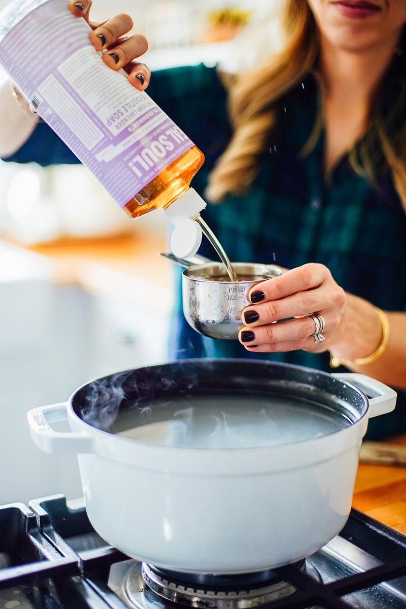 Adding liquid castile soap to the dutch oven.