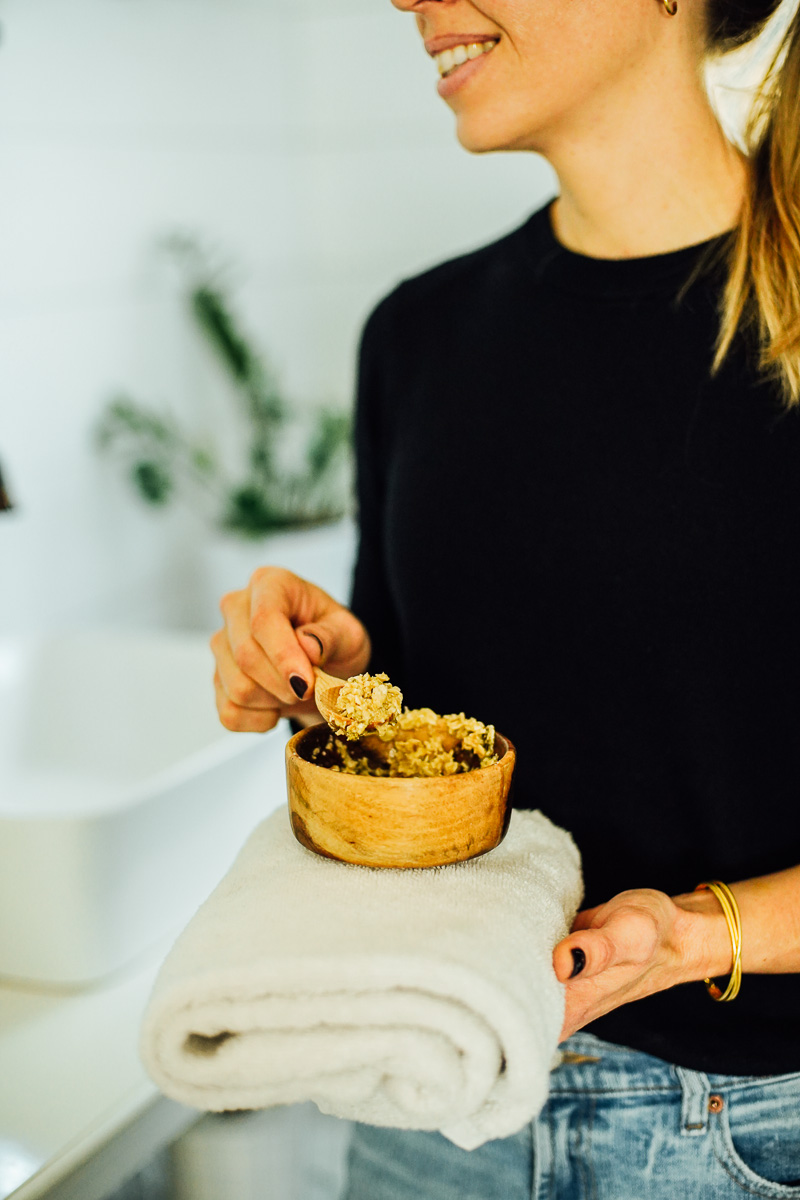 Holding a bowl with oatmeal mask inside, ready to apply. 