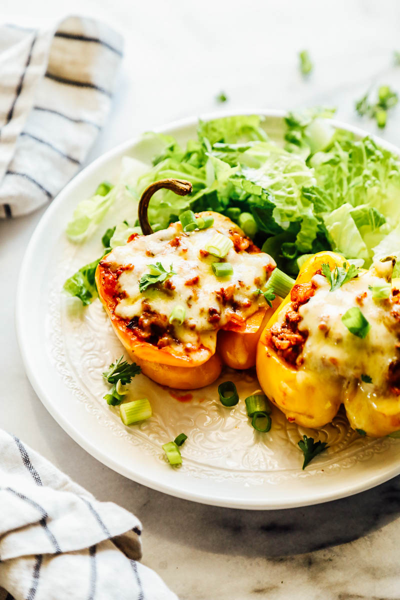 Cooked bell peppers on a plate with salad.