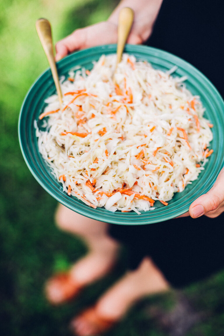 Greek yogurt coleslaw in a green ceramic bowl.