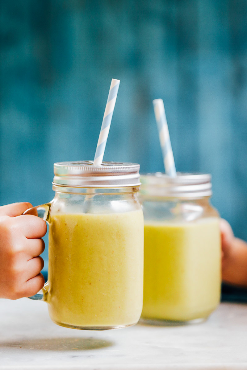 Mango Pineapple Smoothie in glass mason jars with straws.