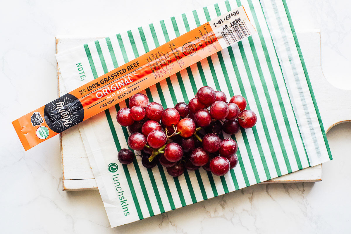 Beef jerky stick and grapes. 