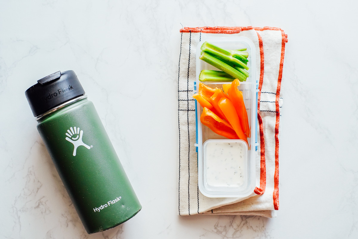 ranch dip, celery, bell peppers in a snack container. 