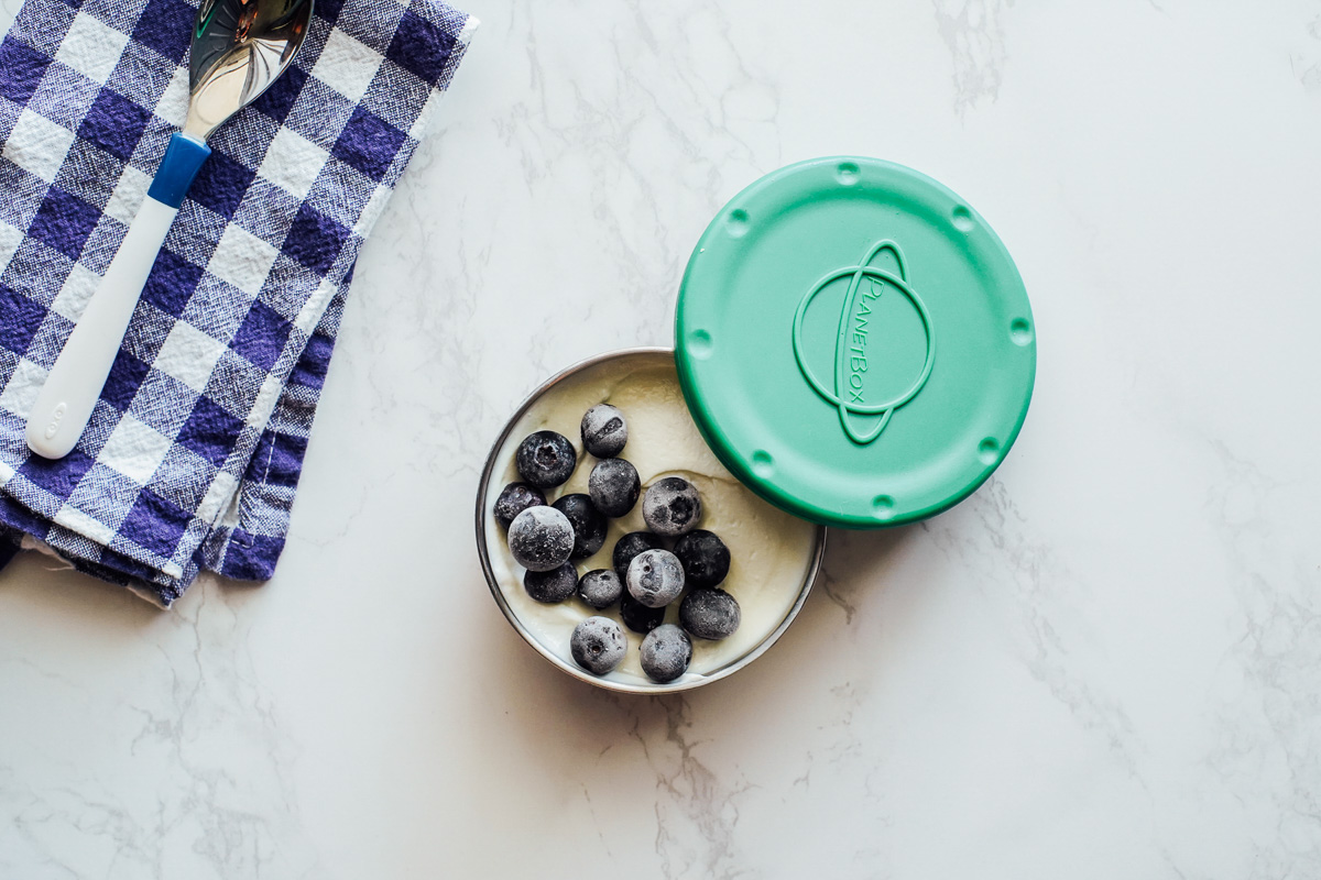 Yogurt and frozen berries in a container. 