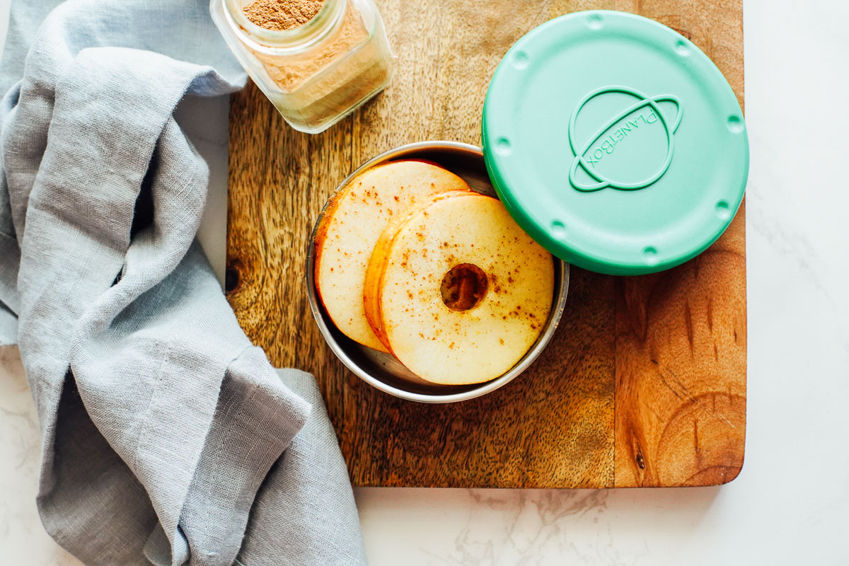 Apple sandwiches made with apple slices and peanut butter in a container. 