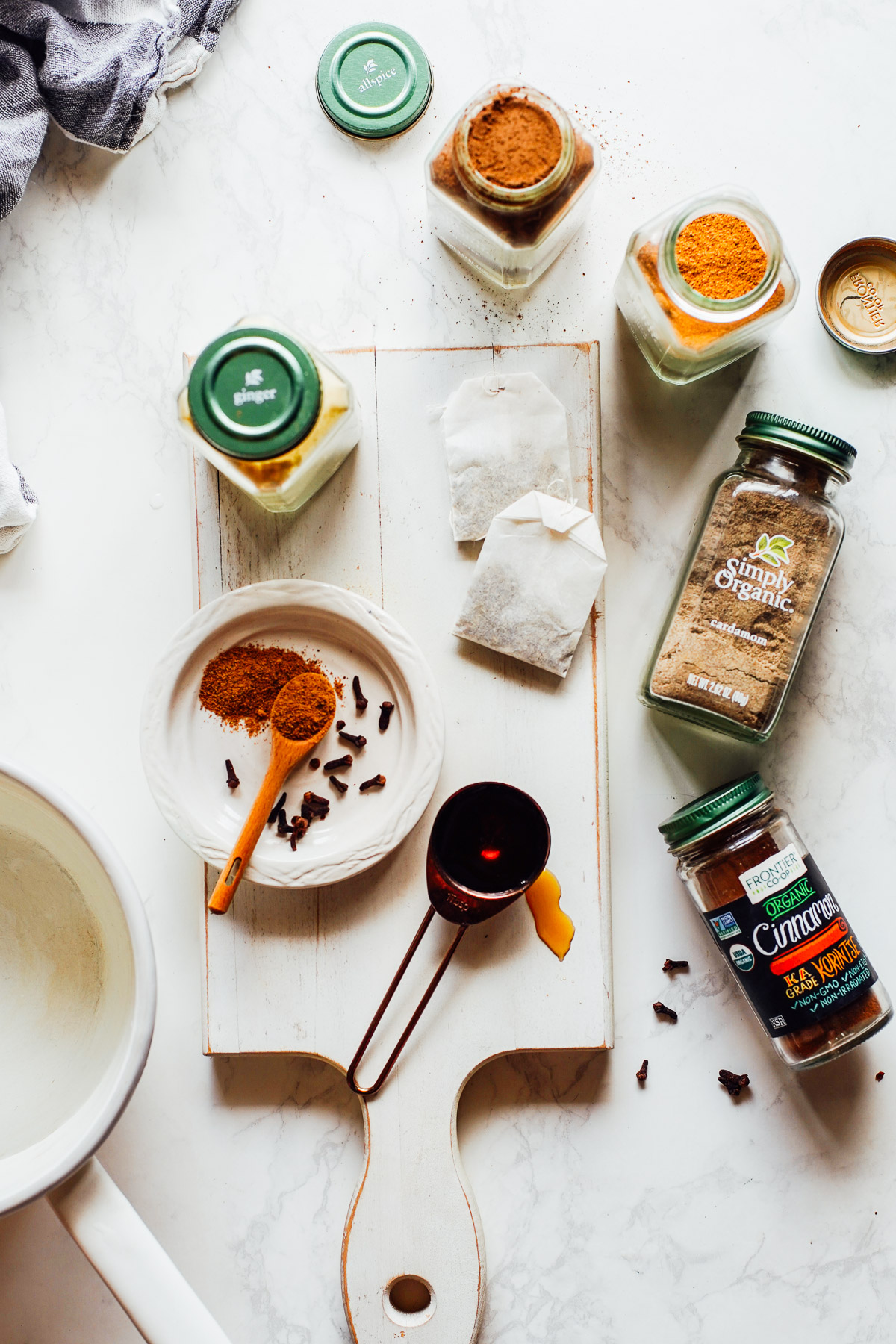 Chai latte ingredients spread on a counter: tea bags and spices.