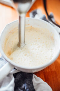 Frothing milk in a saucepan with an immersion blender.