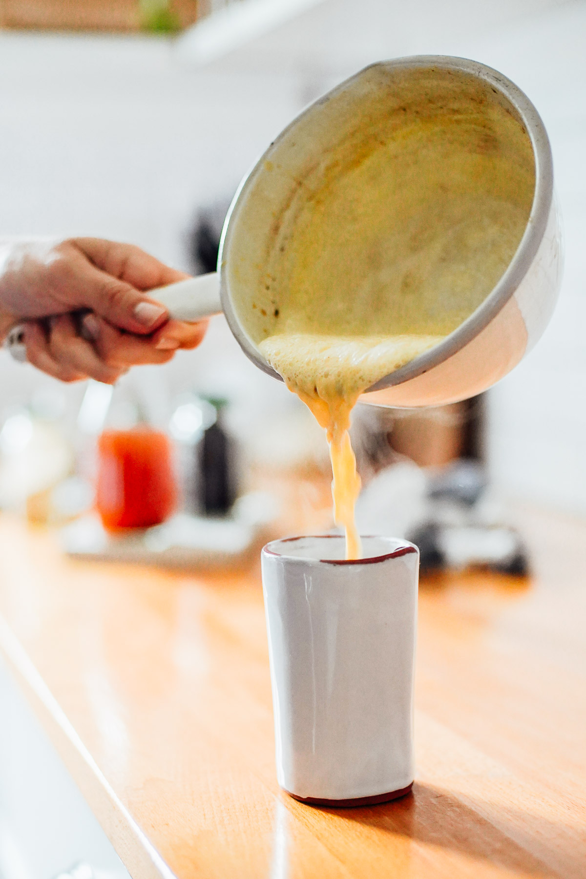 Pouring the frothed milk into a mug.