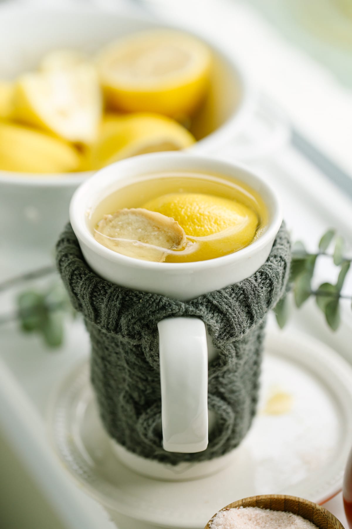 Tea in a white mug with fresh lemon and ginger.