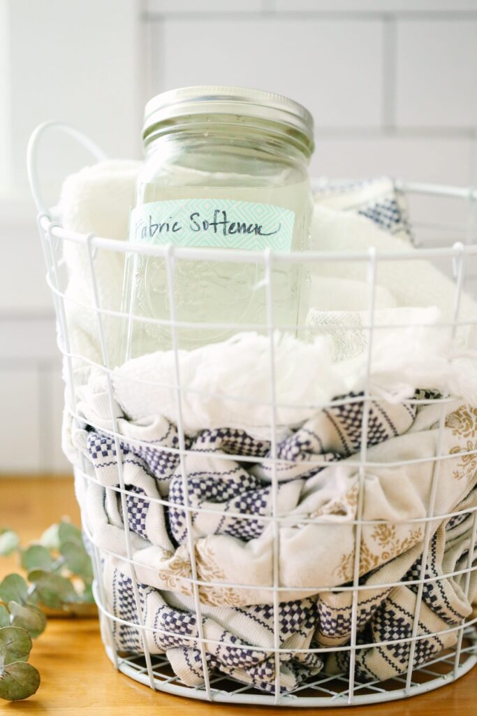 Vinegar in s mason jar in a laundry basket. 