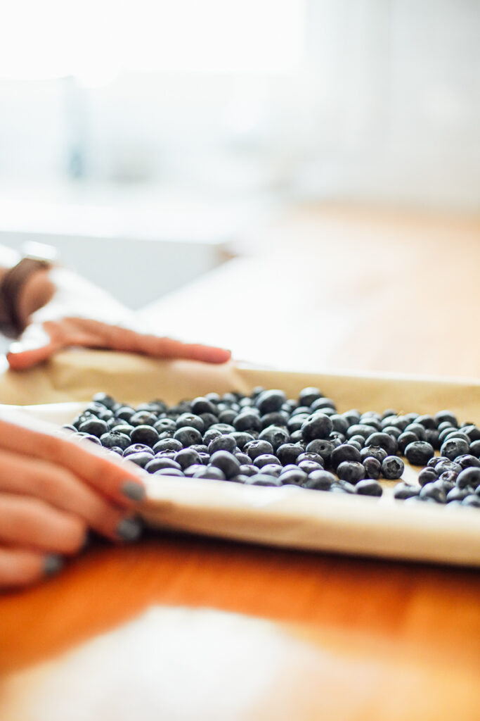 Fresh blueberries on a sheet pan ready to freeze.