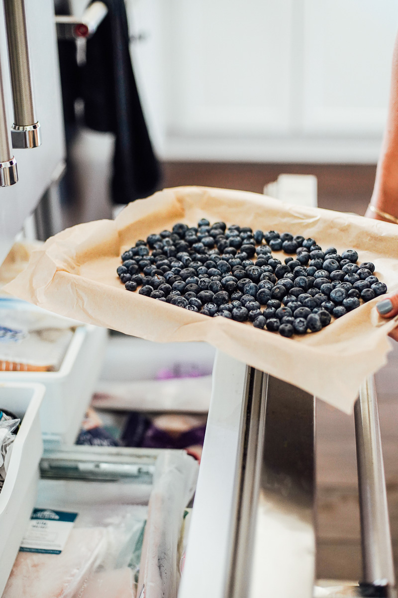 Placing berries on a sheet pan in the freezer.