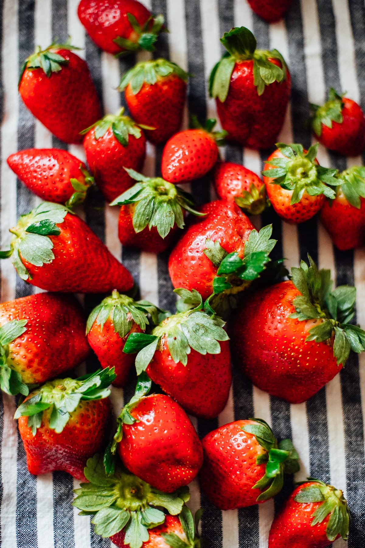 Strawberries drying on a towel on the counter.