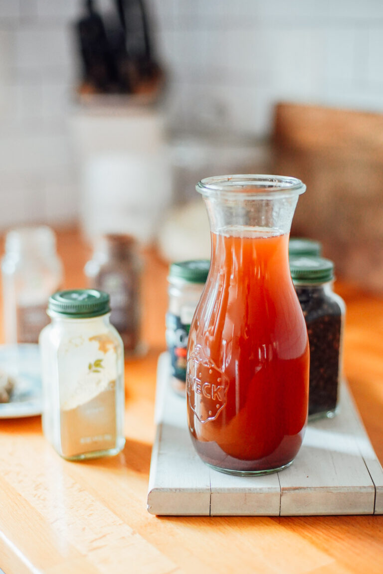 Chai concentrate in a glass jar on the counter with spices.