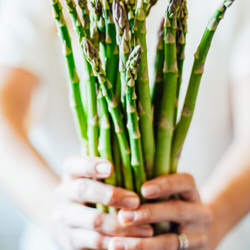 Hands holding a fresh asparagus.