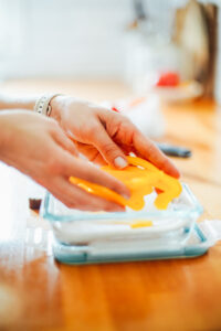 Placing sliced bell pepper sticks in an airtight container with a paper towel.