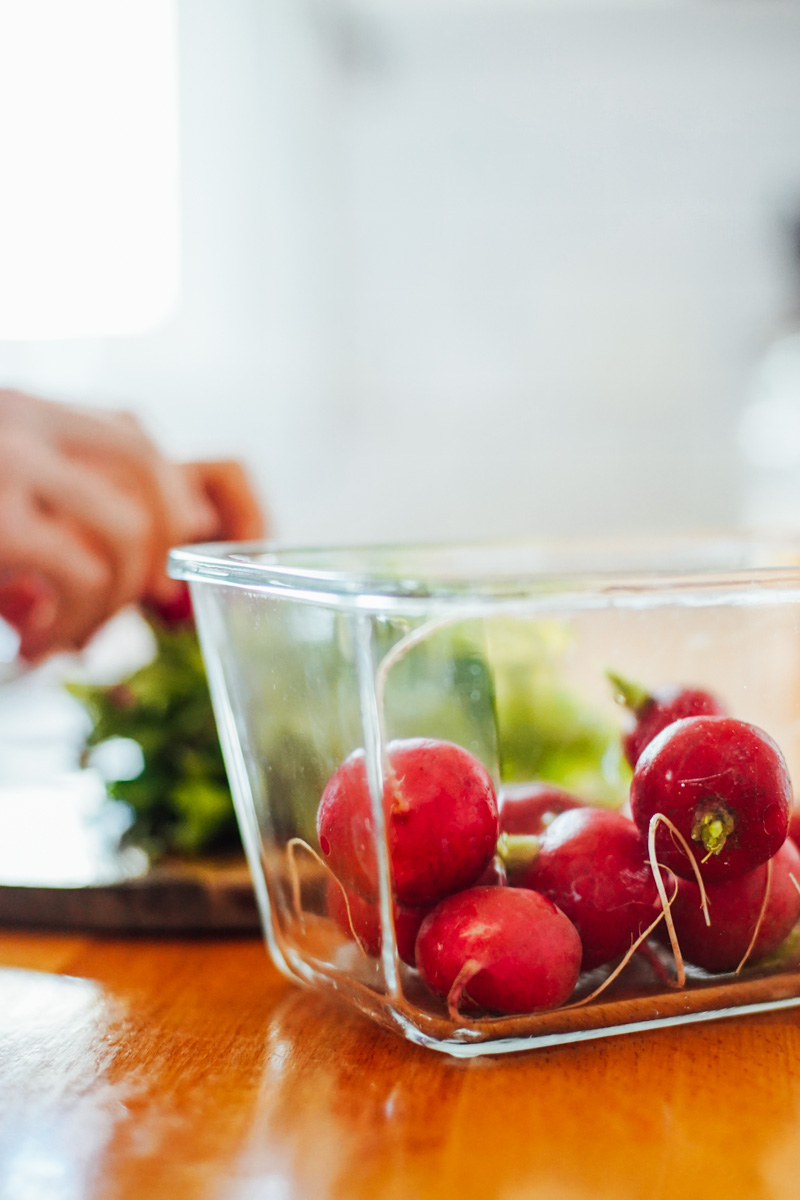 Raw radishes in a glass jar on the kitchen counter.