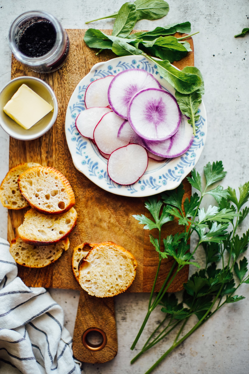 Purple watermelon radish slices on a blue and white plate.