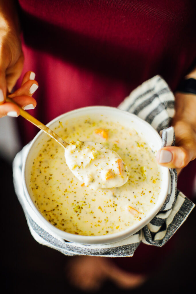 Spooning soup from a bowl, hands holding the bowl with a napkin.