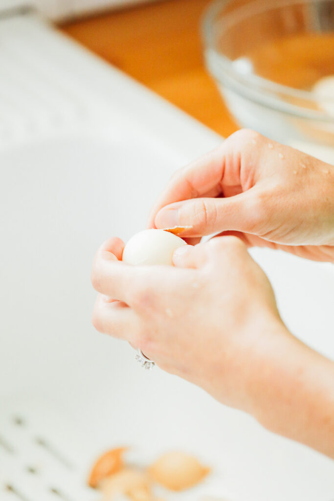 Peeling the hardboiled eggs under running water.