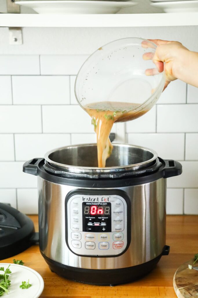 Adding gravy ingredients to the Instant Pot. 