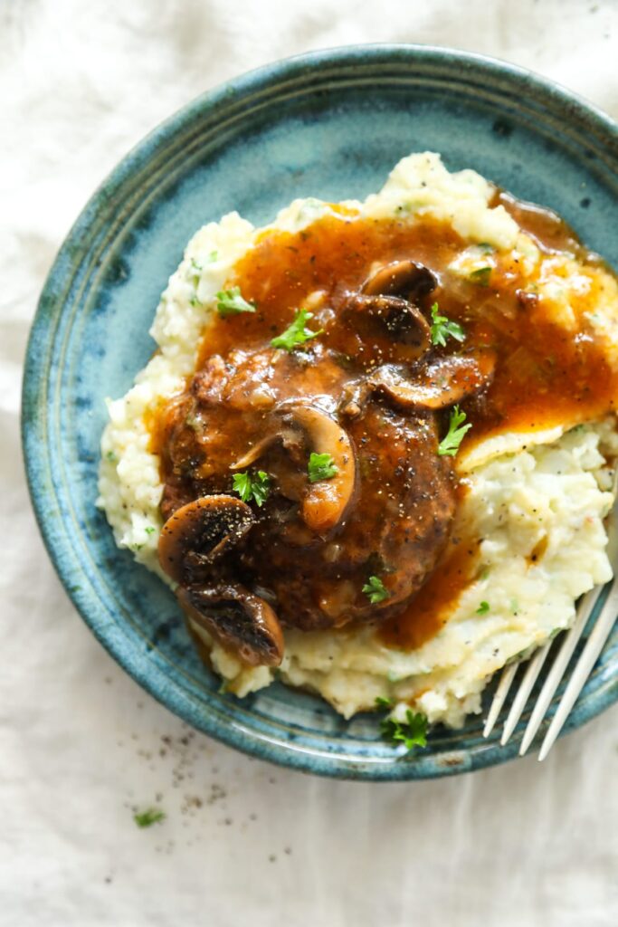 Salisbury steak on top of mashed potatoes.