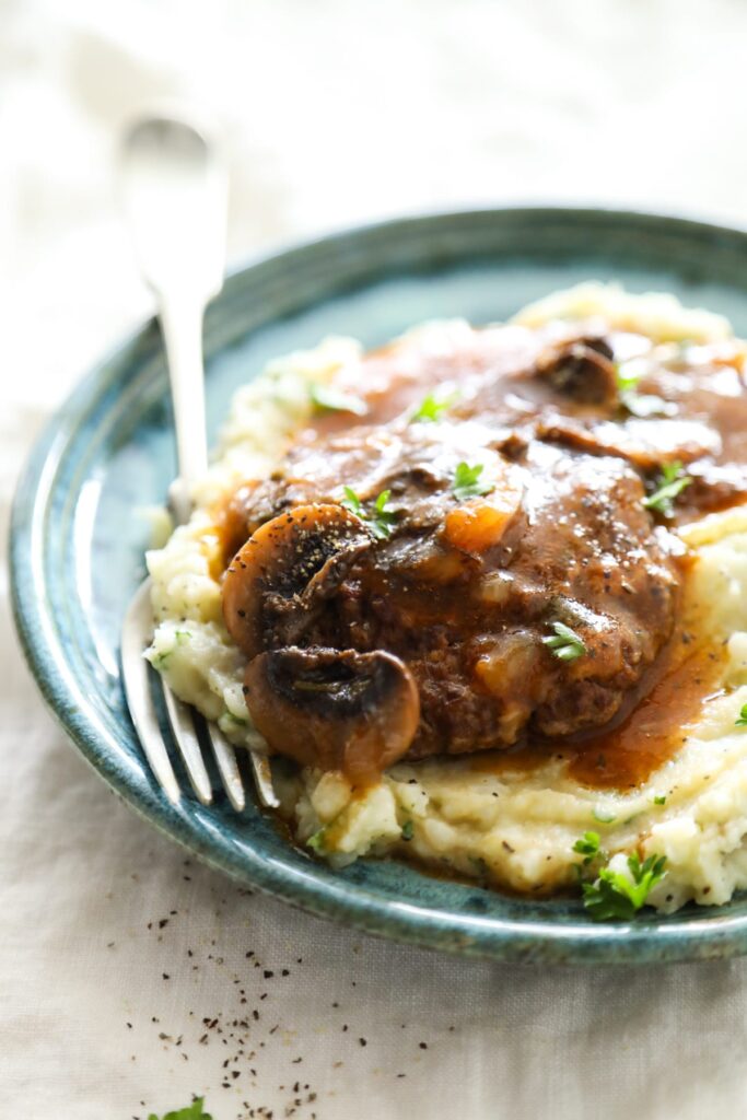 Salisbury steak on a plate with mashed potatoes