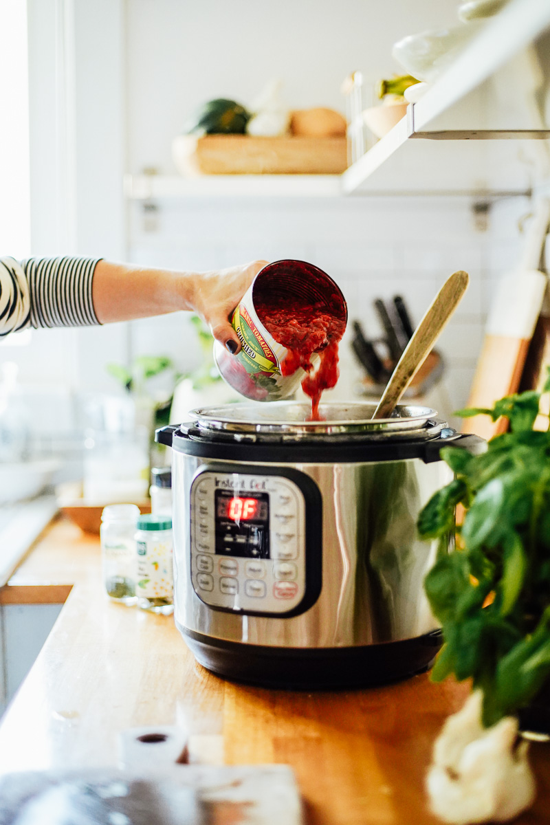 Pouring the canned tomatoes into the Instant Pot.