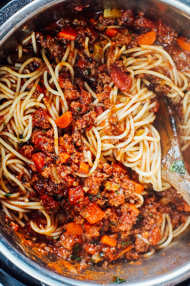 Mixing the bolognese sauce with the pasta.