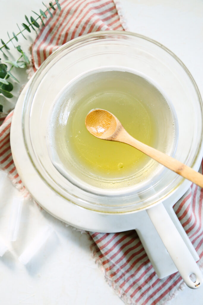 Melting beeswax and shea butter over medium heat in a glass bowl on top of a saucepan. 