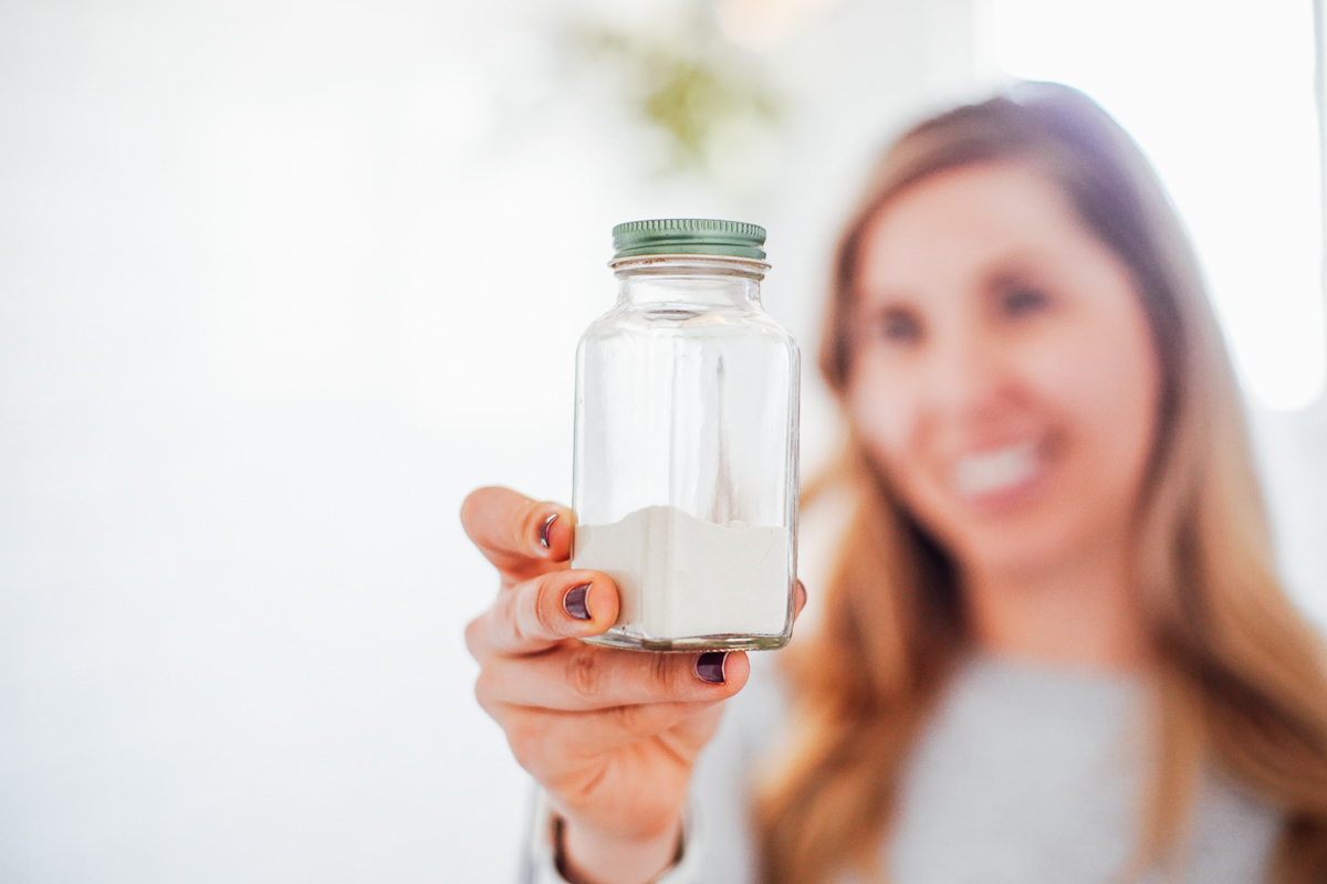 Holding a bottle of homemade dry shampoo.