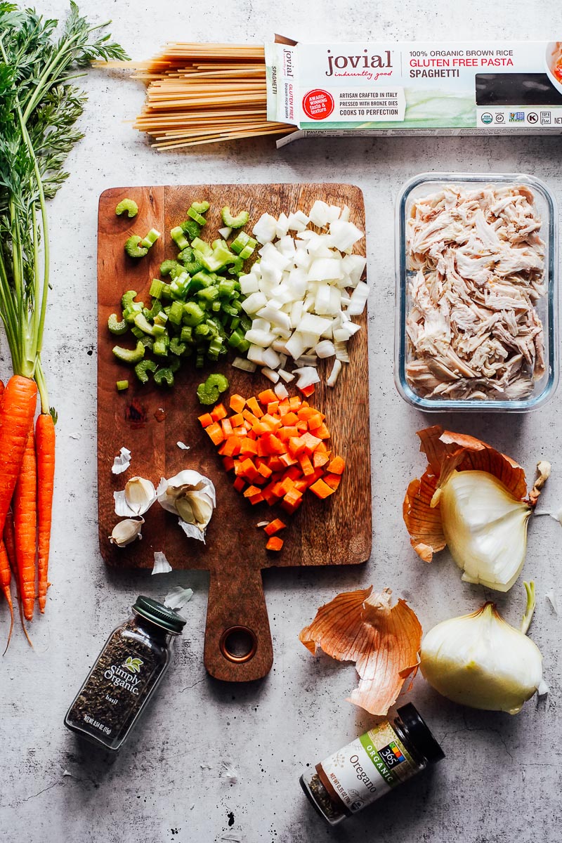 Soup ingredients on the counter: chicken, noodles, veggies. 