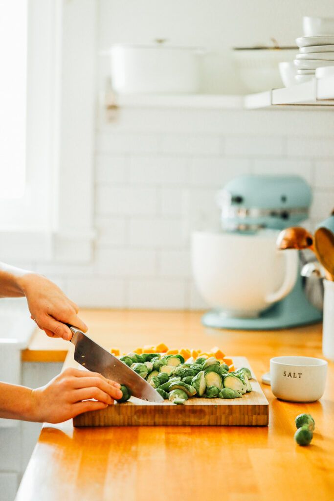 Cutting brussels sprouts and butternut squash. 