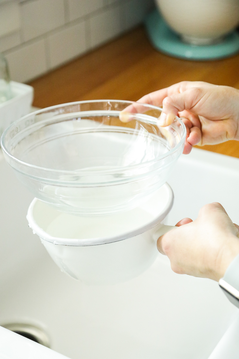 Making a double boiler by placing a glass bowl on top of a saucepan.