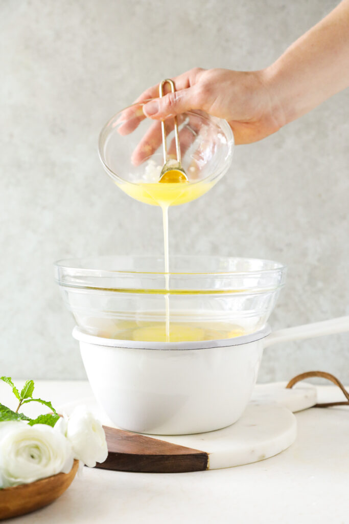 Pouring the carrier oil mixed arrowroot starch into the melted butter.