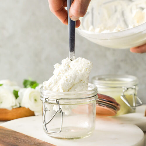 Spooning whipped body butter into a jar