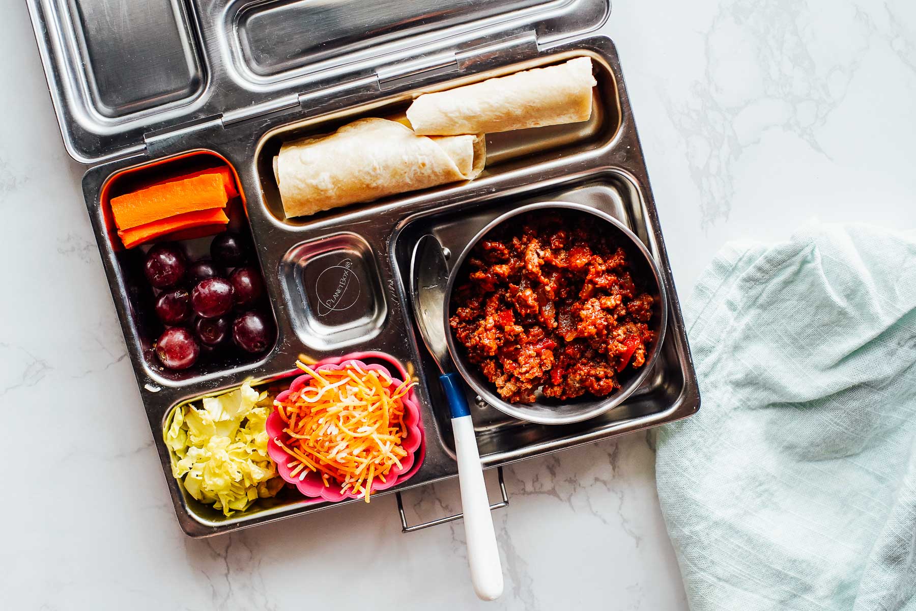 Taco lunchable: taco meat, tortilla, grapes, carrots, lettuce, cheese.