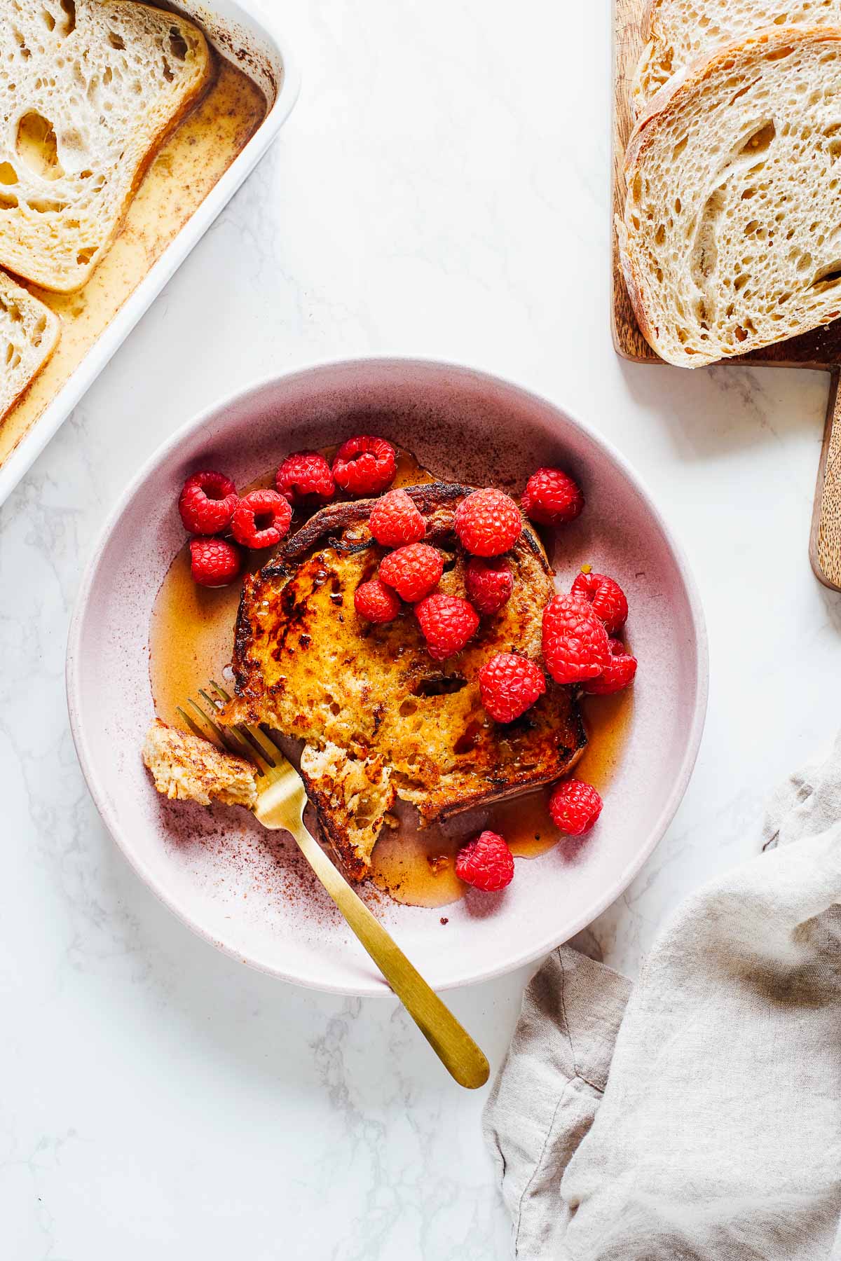 French toast on a pink plate cut with a fork.