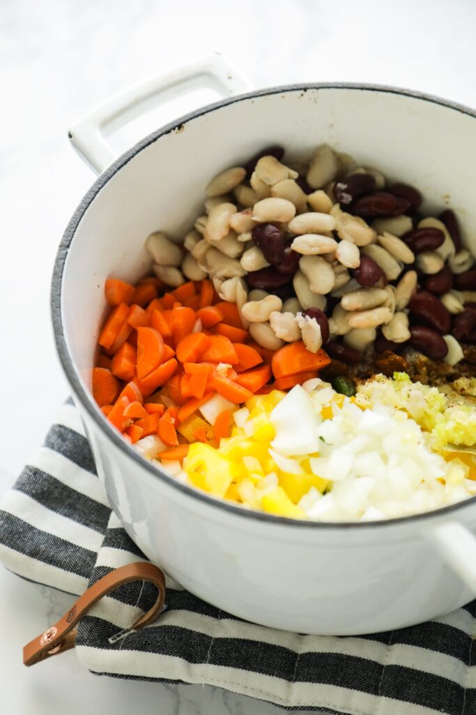 Ingredients in the dutch oven: beans, carrots, bell peppers, onion. 