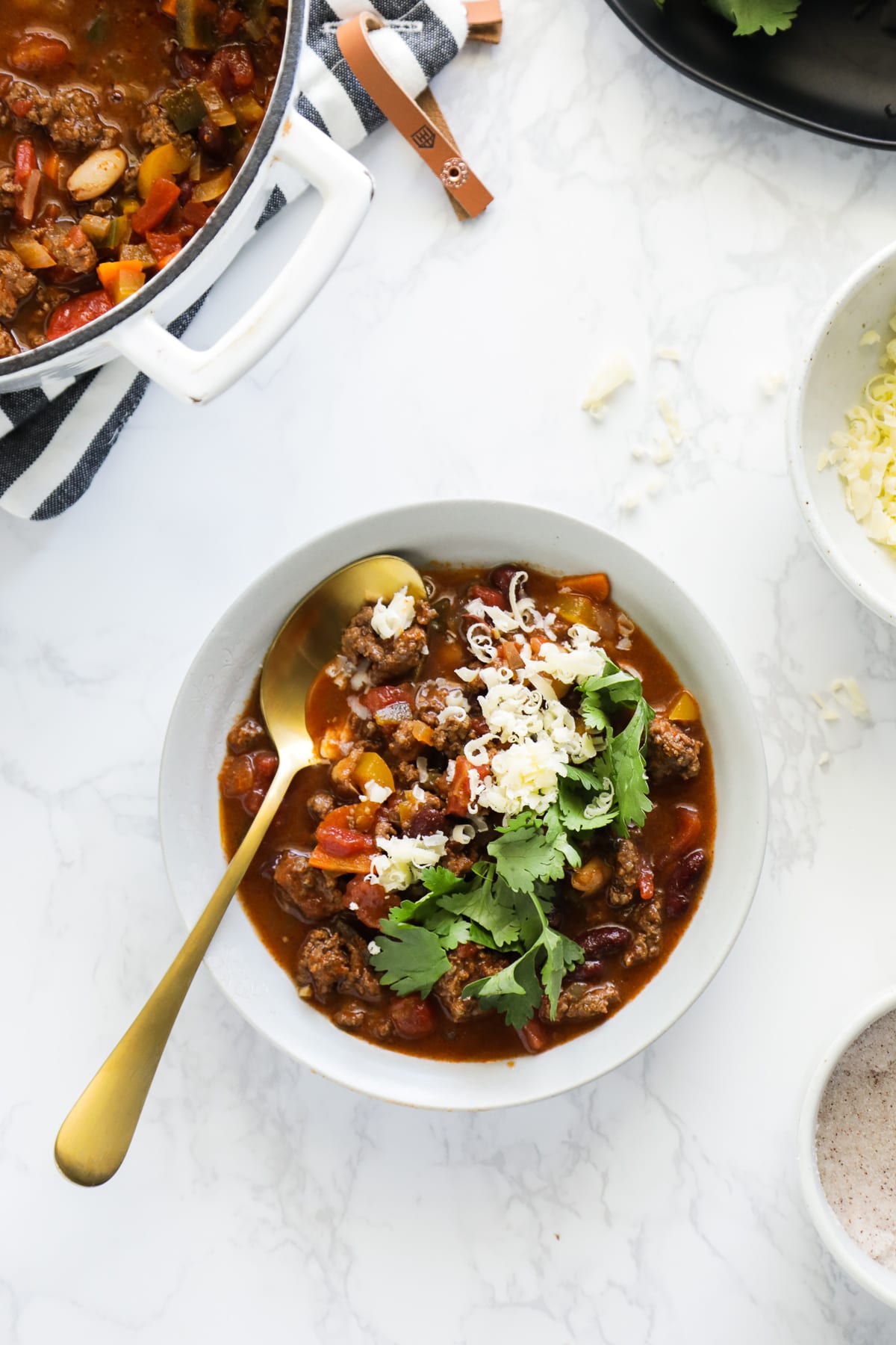 Toppings on the chili: cheese, cilantro. 