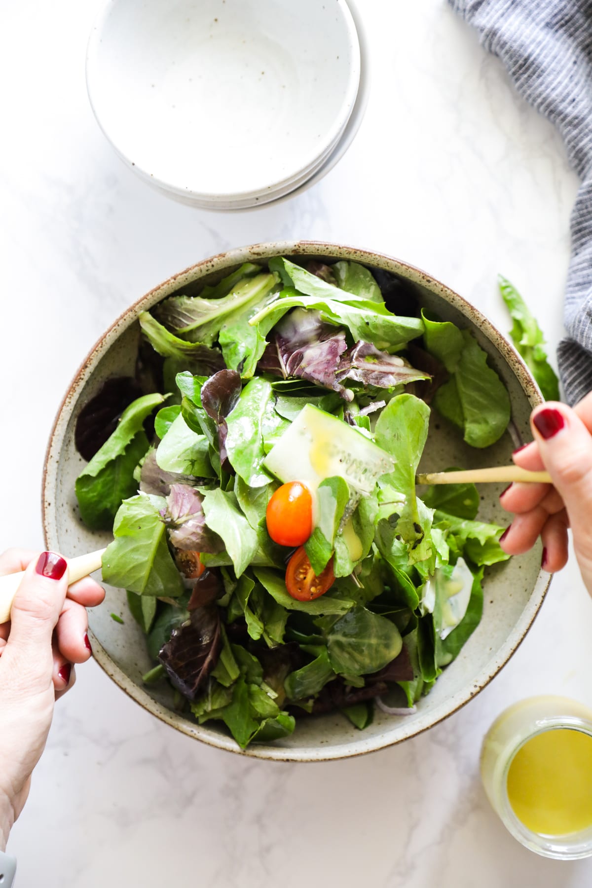 Combining salad greens and salad dressing. 